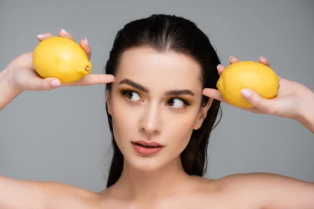 femme tenant deux citrons dans ses mains