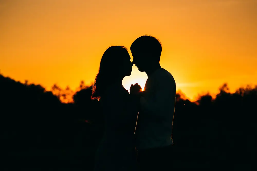deux amoureux au coucher du soleil face à face