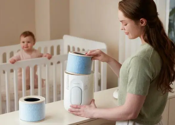 maman changeant le filtre du purificateur d'air dans la chambre de son bébé