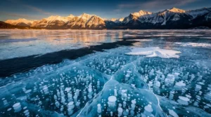 Lac Abraham au Canada : photographier les bulles de méthane gelées Vue panoramique du lac Abraham en hiver avec des milliers de bulles de méthane figées sous la glace translucide et les Rocheuses canadiennes en arrière-plan