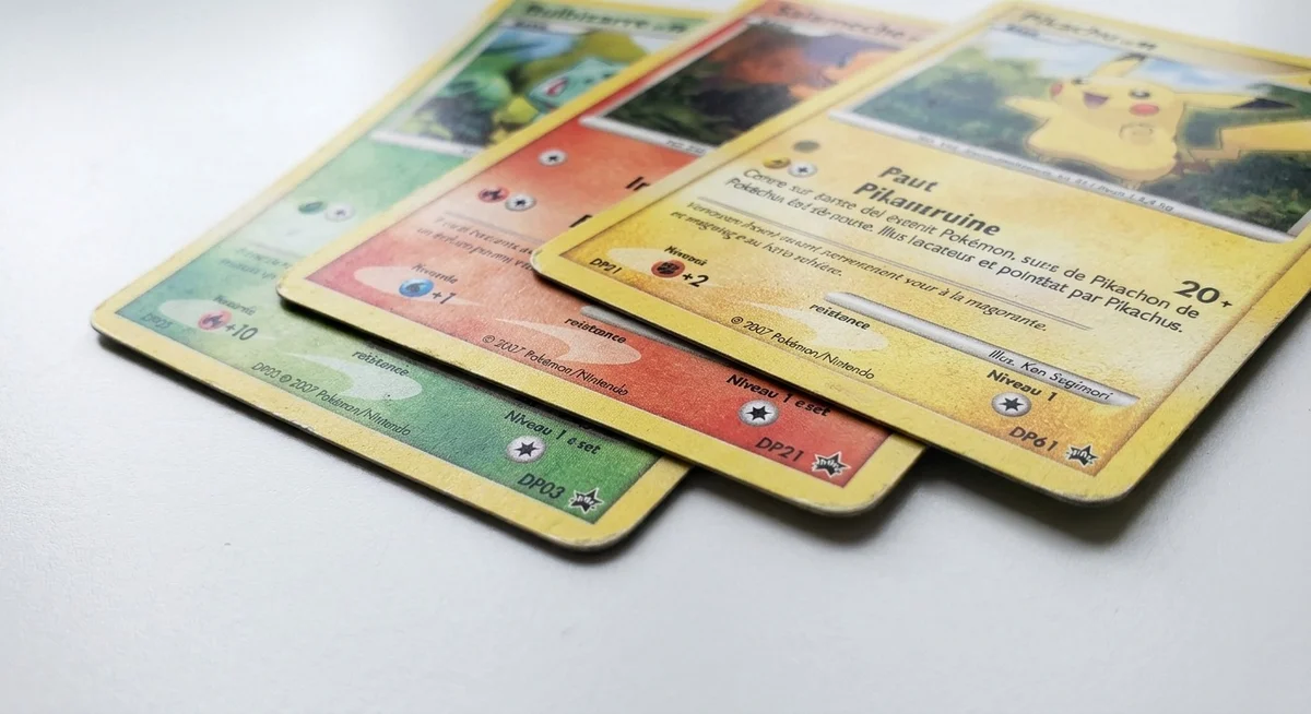 Symboles de rareté des cartes Pokémon expliqués Gros plan sur les symboles de rareté en bas d'une carte Pokémon : cercle, losange, étoile