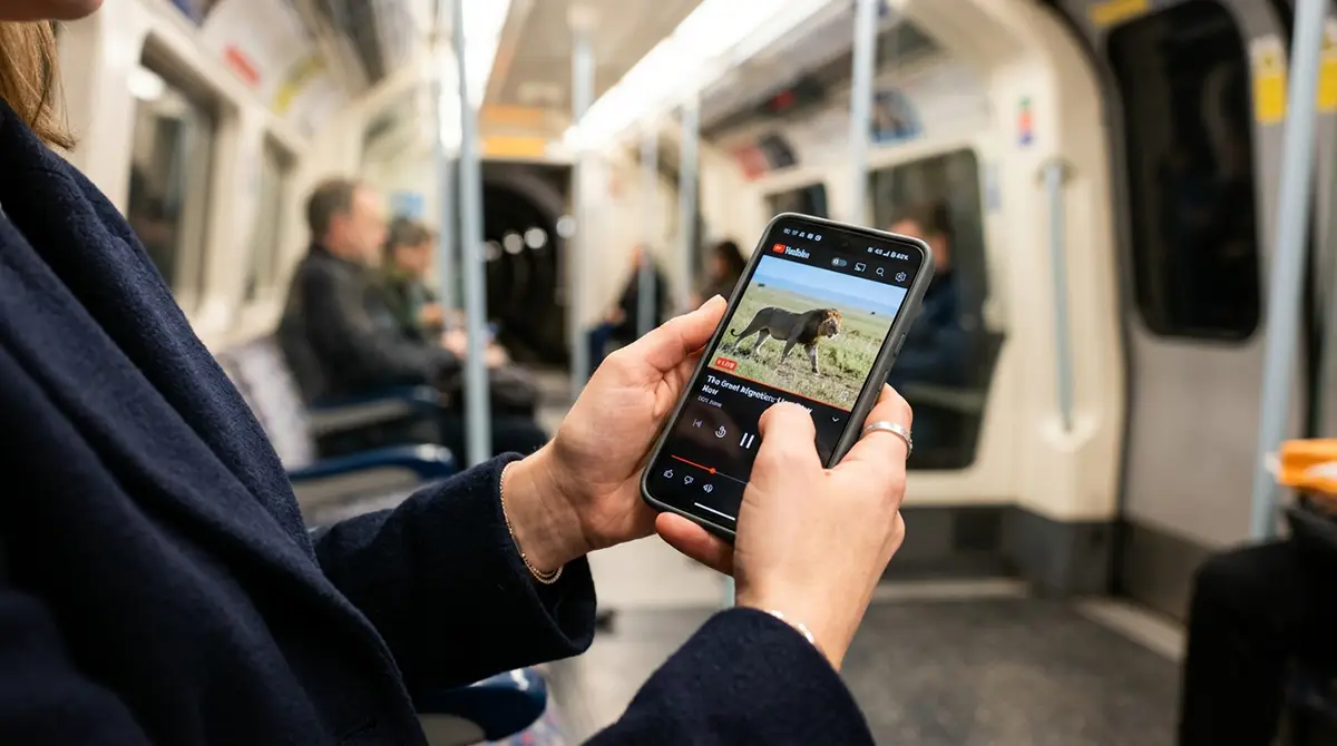 Voyageur utilisant son smartphone avec un signal 4G-5G fort dans une rame de métro moderne équipée d'un système DAS