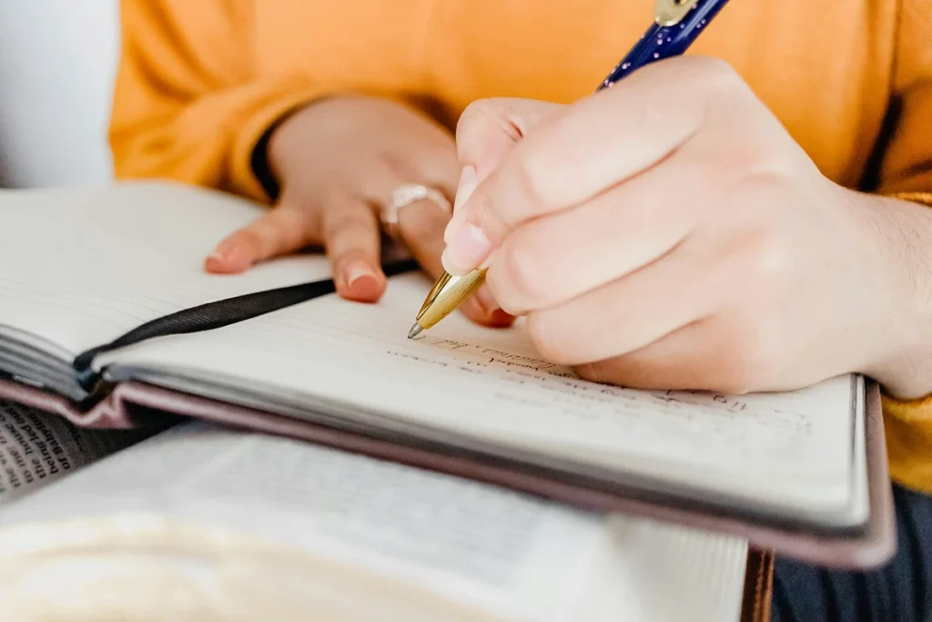 Back to School 2026 – Comment aménager un espace de travail qui favorise vraiment la concentration Etudiante qui écrit sur son carnet - back to school 2026