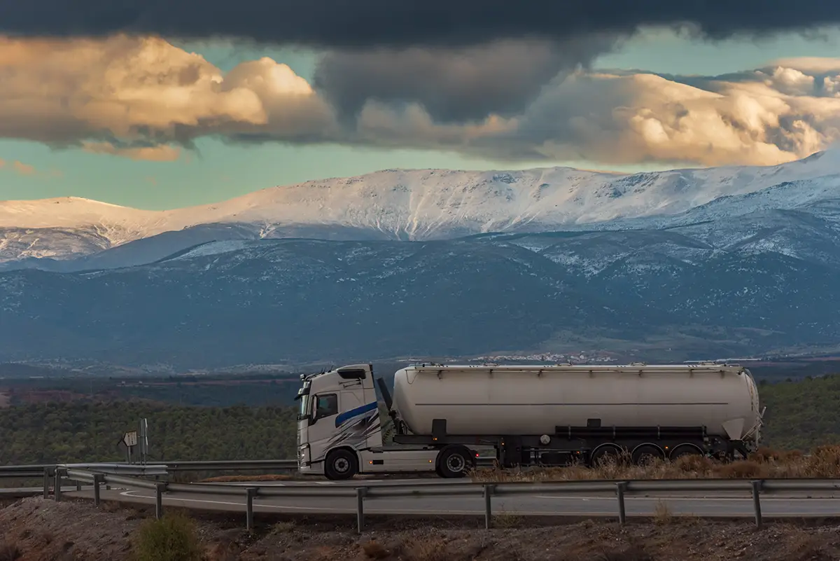 Vue de côté d'un camion-citerne circulant avec vue sur les Pyrénées en arrière-plan